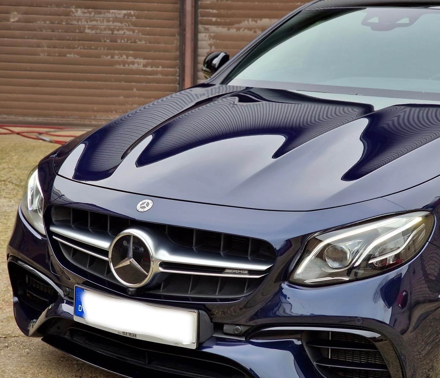 Dunkler Mercedes mit spiegelndem Lackdetail